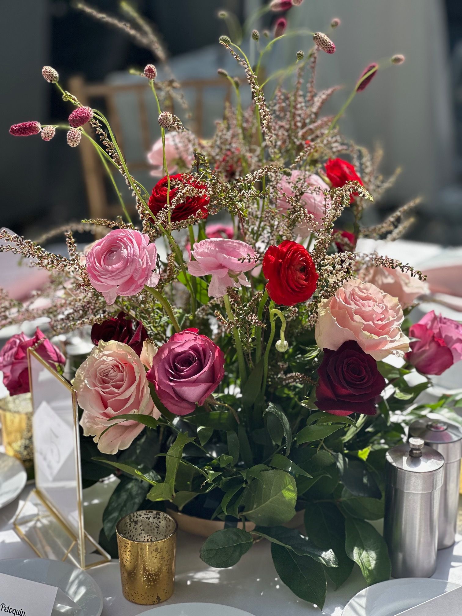 A table with a vase of pink and red flowers on it.
