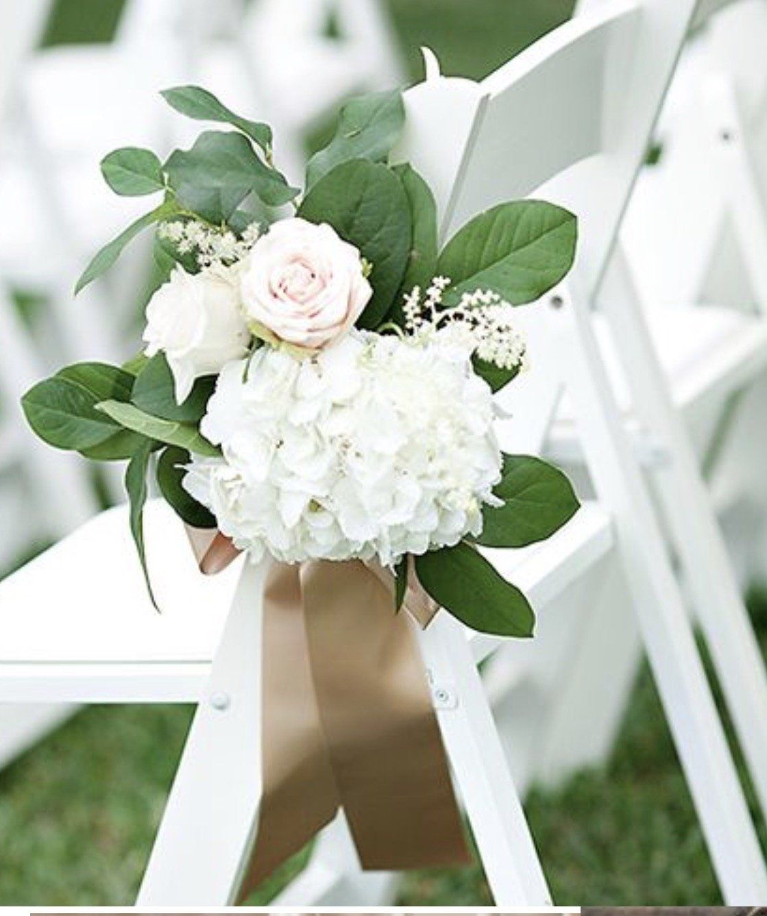 A white folding chair with a bouquet of white flowers on it