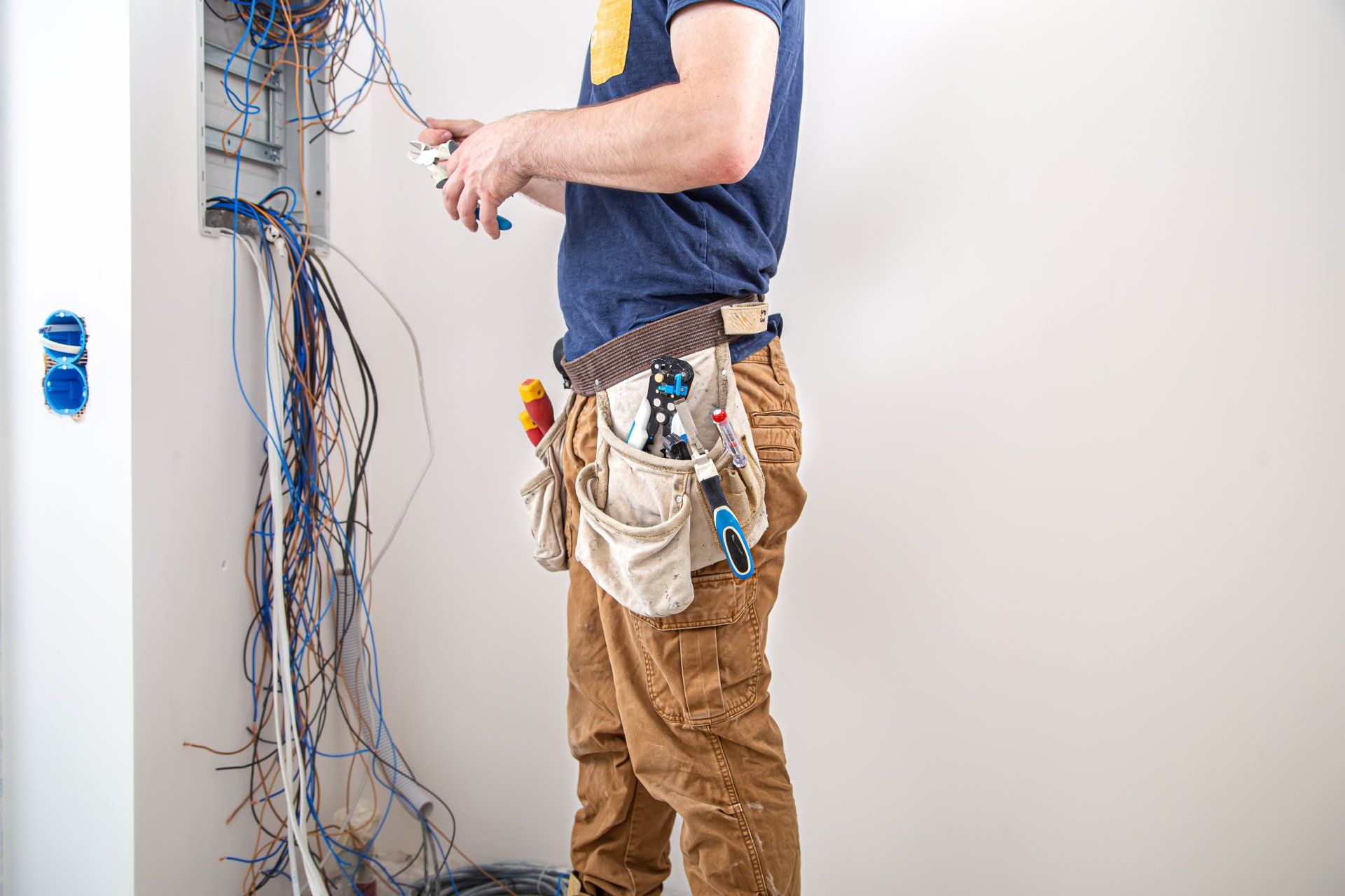 electrician working on electric panel wires