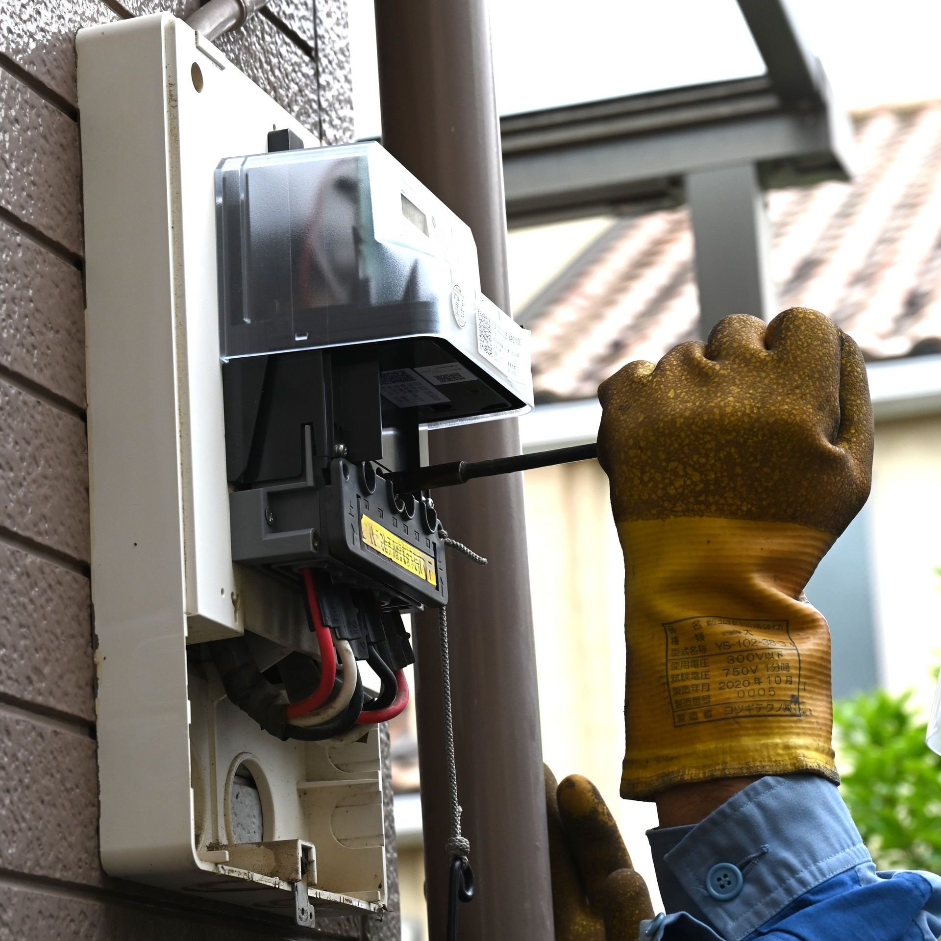 A person is pressing a button on an electrical box.