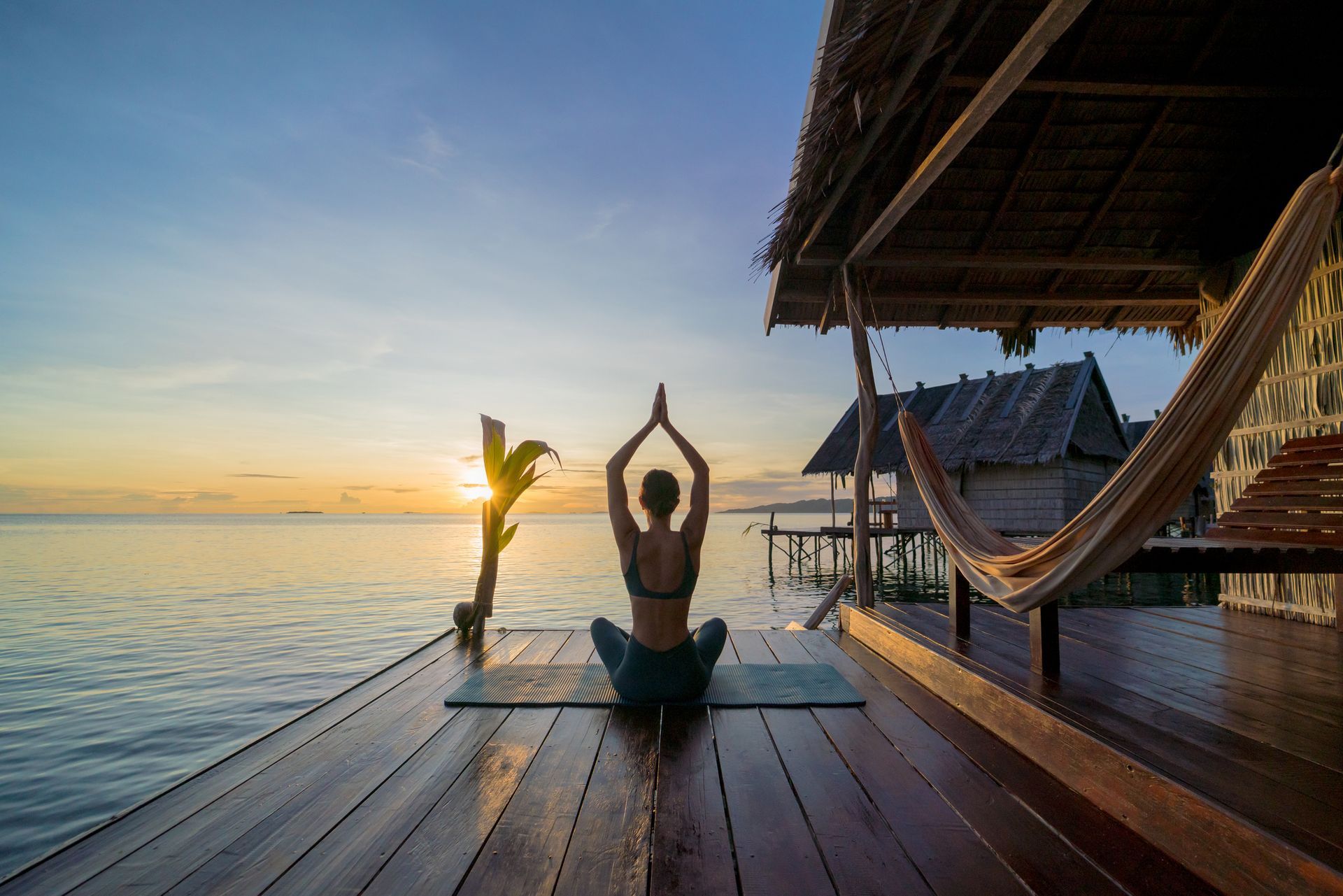 A woman with a backpack is walking through a forest.