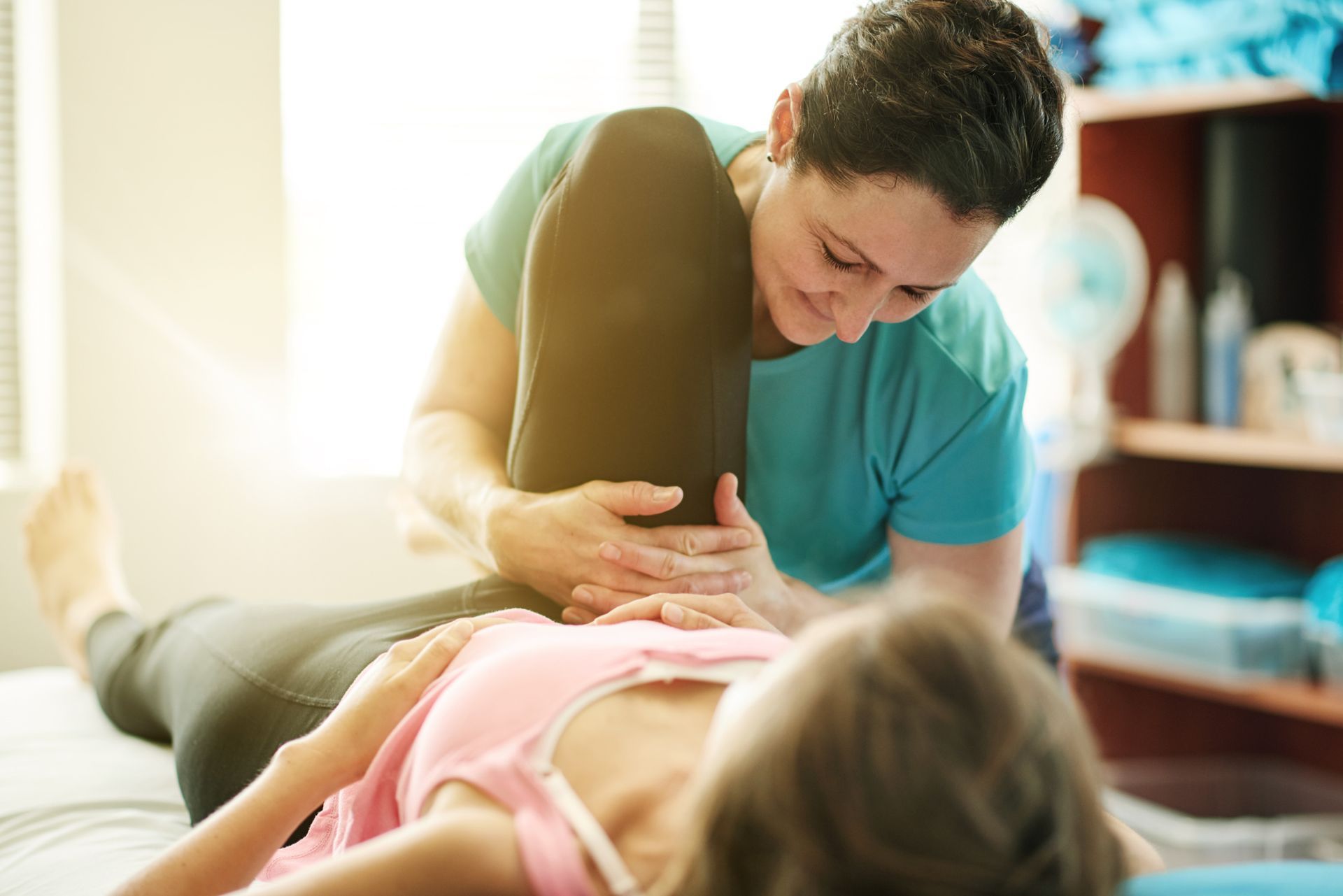A woman is getting a massage on her neck and shoulder.