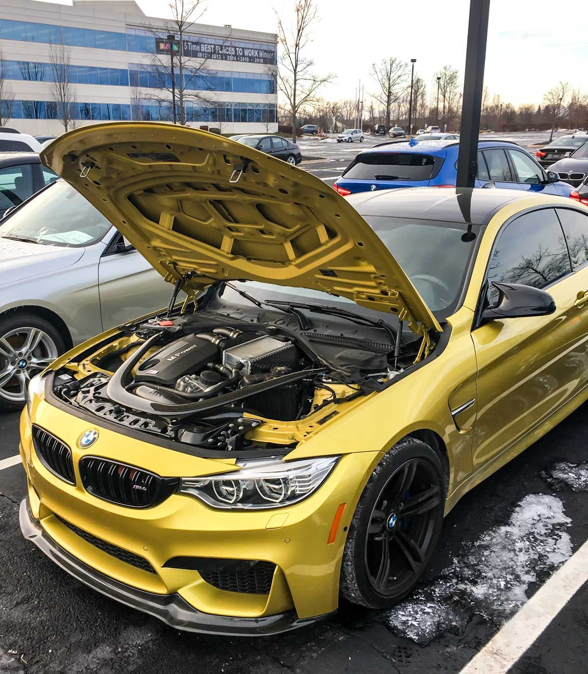 BMW M4 with the hood open showing S55 engine