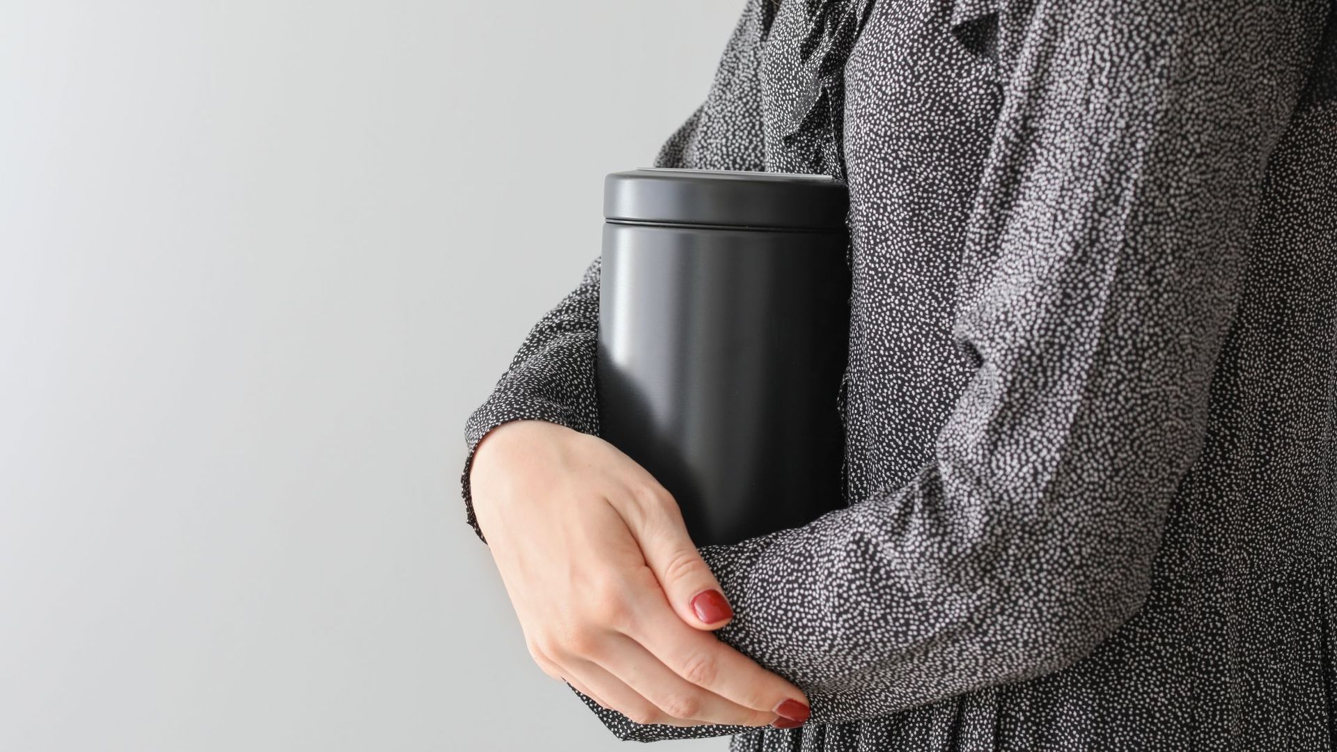person holding a black urn