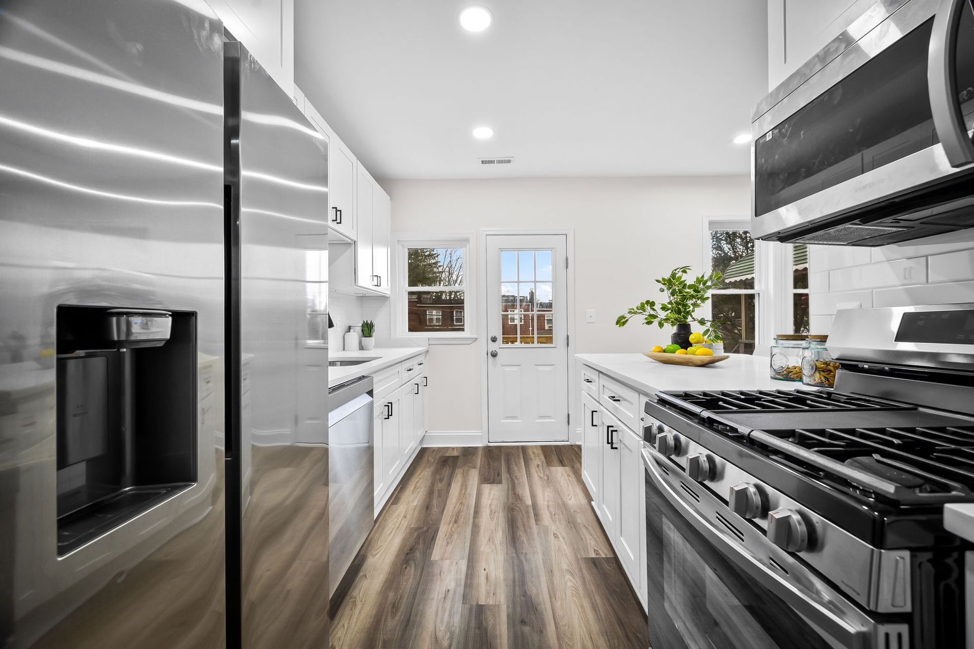 A kitchen with stainless steel appliances and hardwood floors.