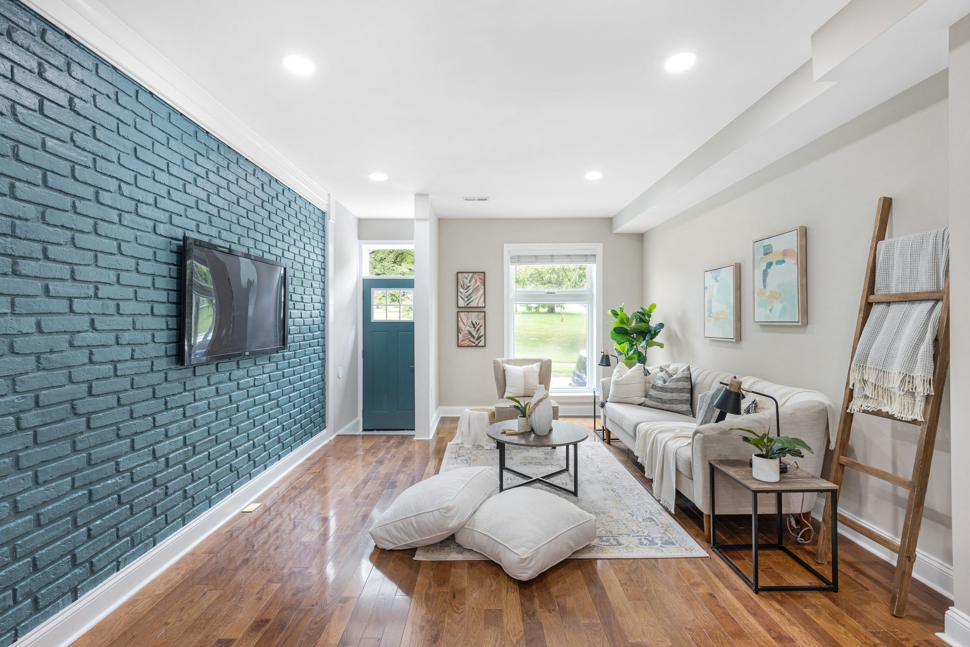 A living room with a blue brick wall and a flat screen tv.