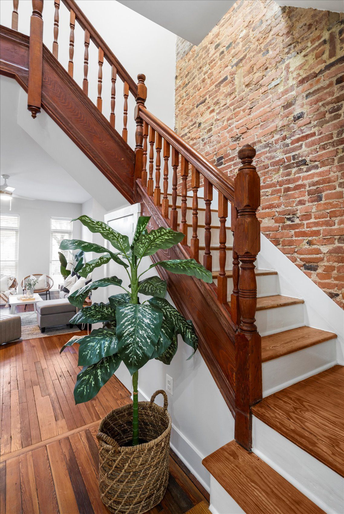 A wooden staircase with a plant in a basket next to it.