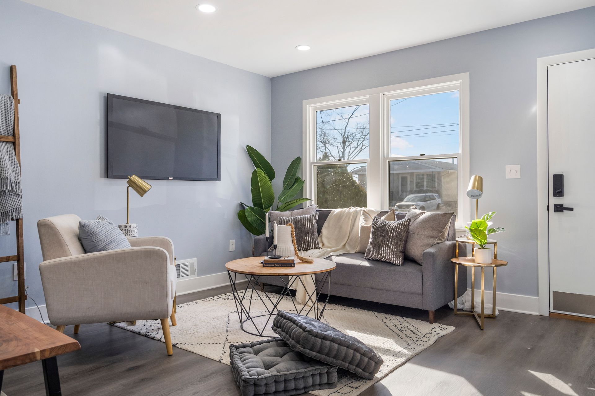 A living room with a couch , chairs , table and television.