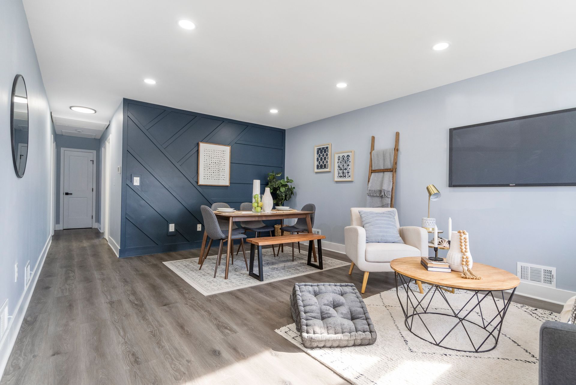 A living room with a table , chairs , coffee table and television.