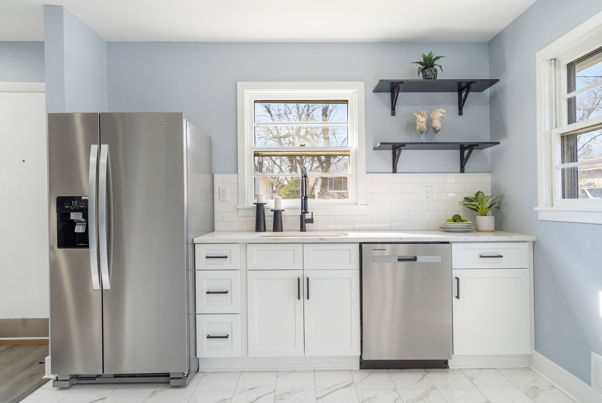 A kitchen with stainless steel appliances and white cabinets.