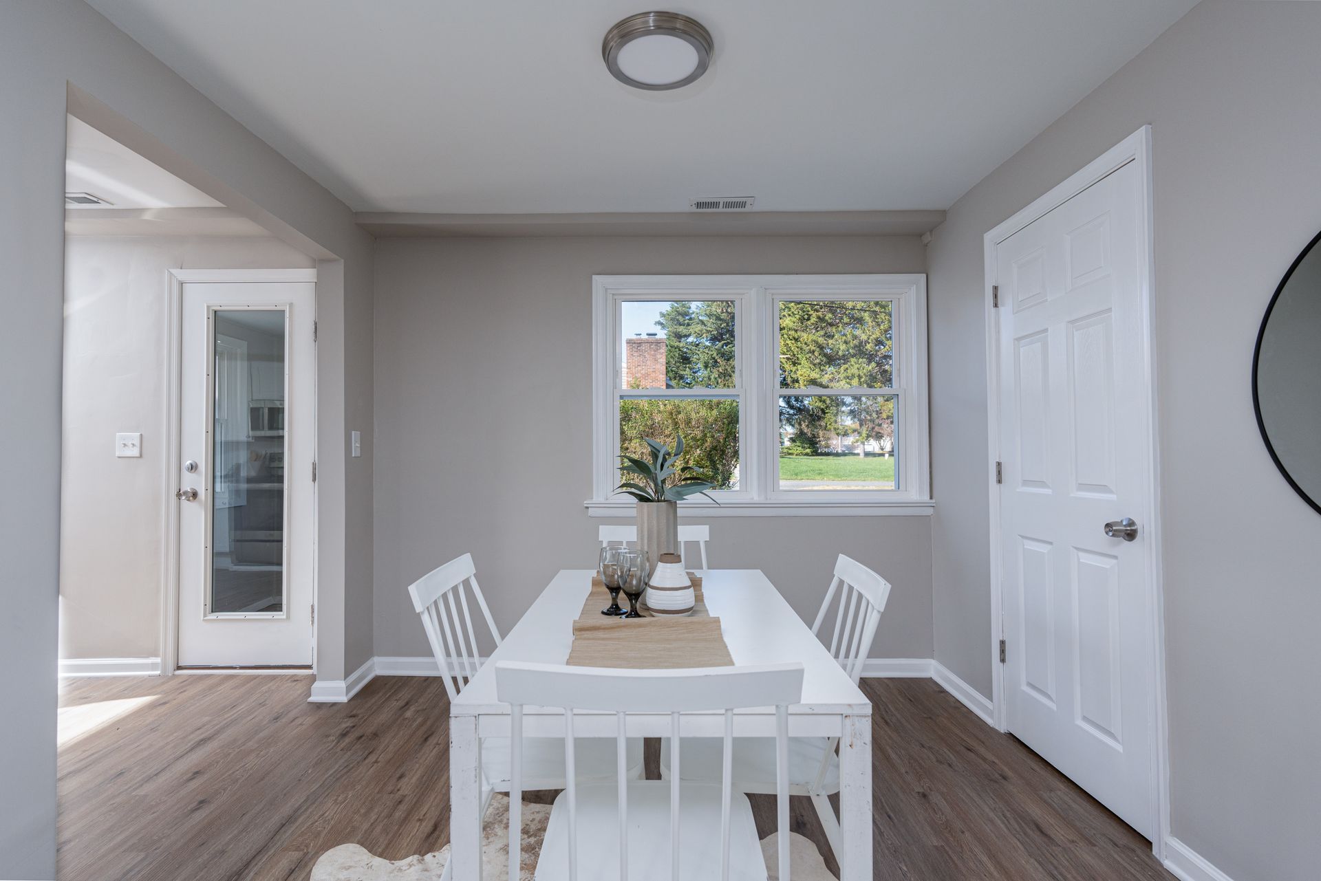 A dining room with a table and chairs and a window.