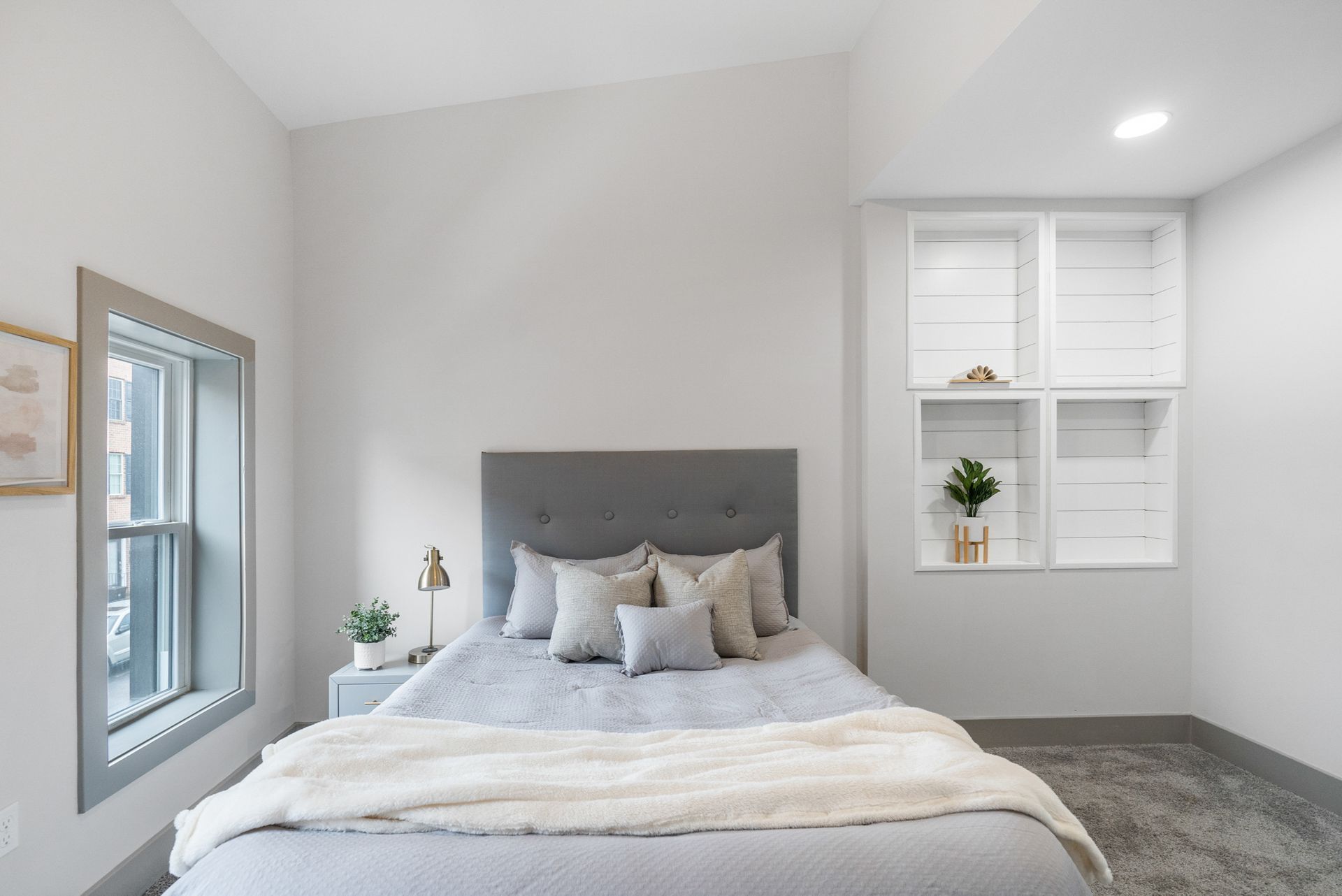 There is a bed in the middle of the room with a window.