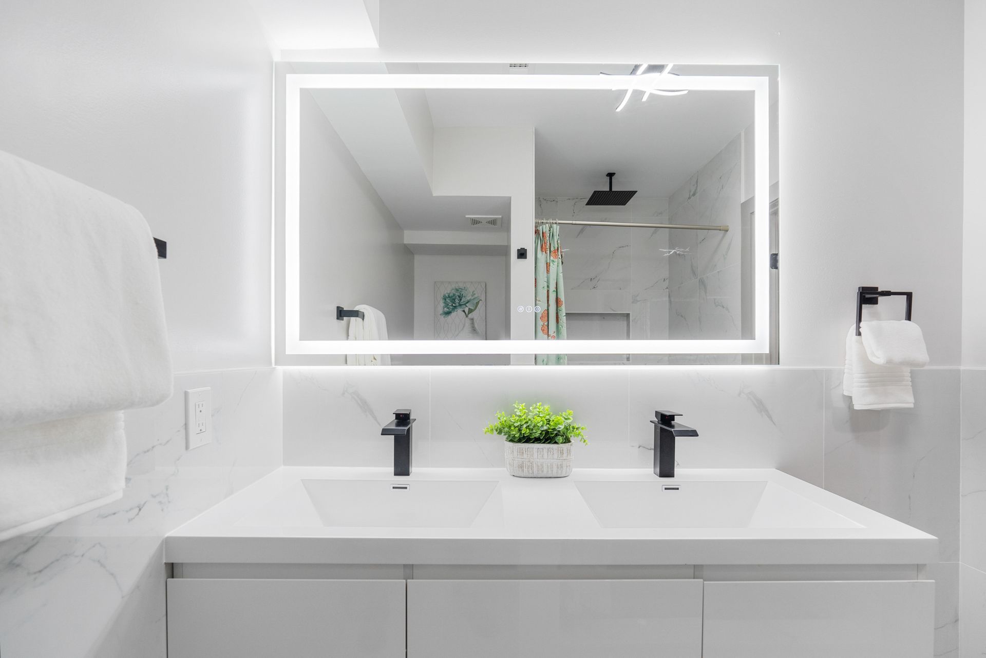 A bathroom with two sinks and a large mirror.