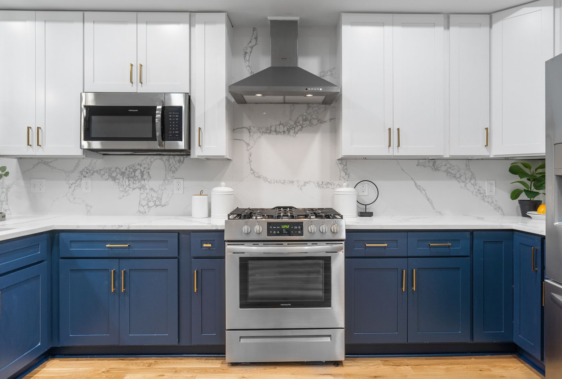 A kitchen with blue cabinets and stainless steel appliances.