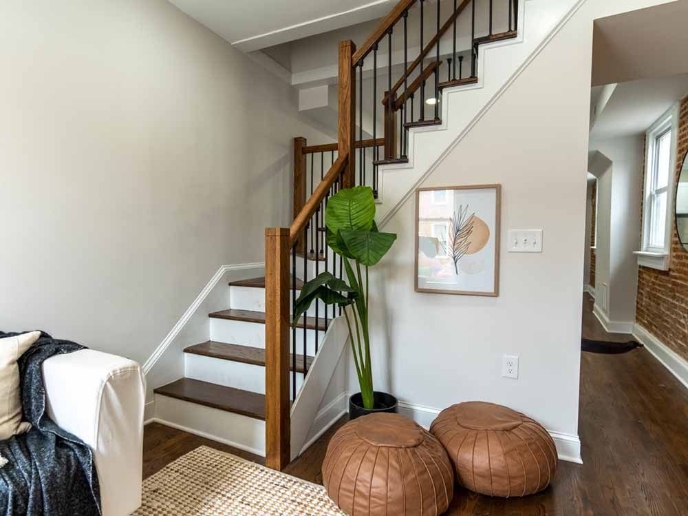 A living room with stairs leading up to the second floor.