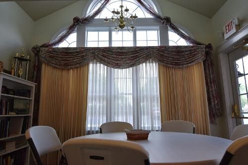 A room with a table and chairs in front of a large window.