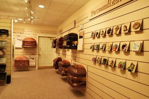 A row of coffins are lined up on a wall in a funeral home.