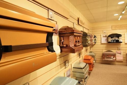 A row of coffins are lined up on a wall in a room.