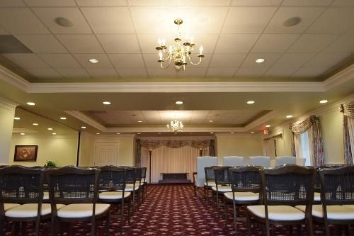 A large room with rows of chairs and a chandelier.