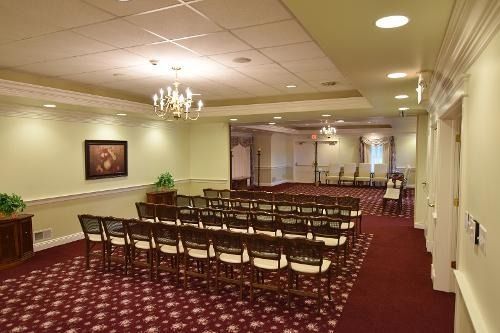 A large room with rows of chairs and a chandelier.