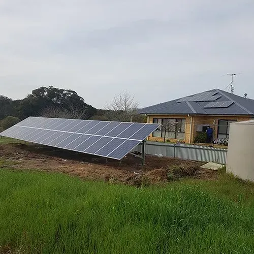 Solar panel installation on grass in front of house