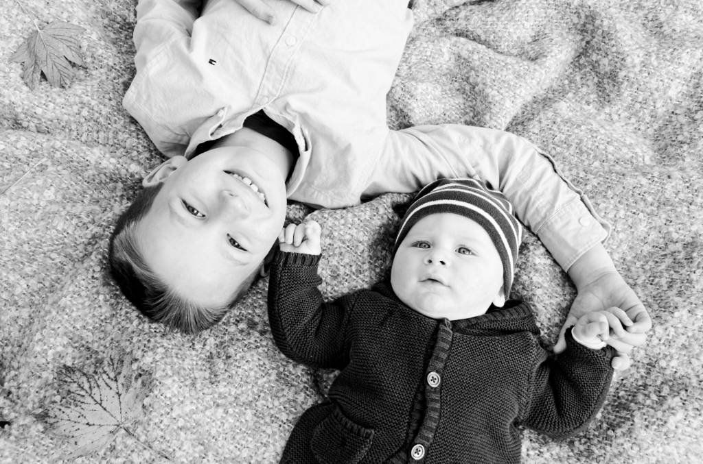 Geschwister, kleine Kinder, kleine Jungs, Baby mit dem Bruder, Herbst, Decke, schwarz-weiß Fotos, lächelnde Kinder.