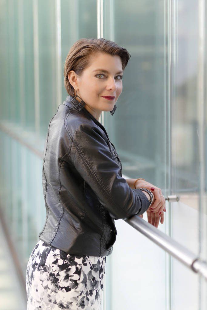 Schwarze Lederjacke, geblümtes Kleid, grüne Augen, grünes Glas, blaues Glas, Vitrine.