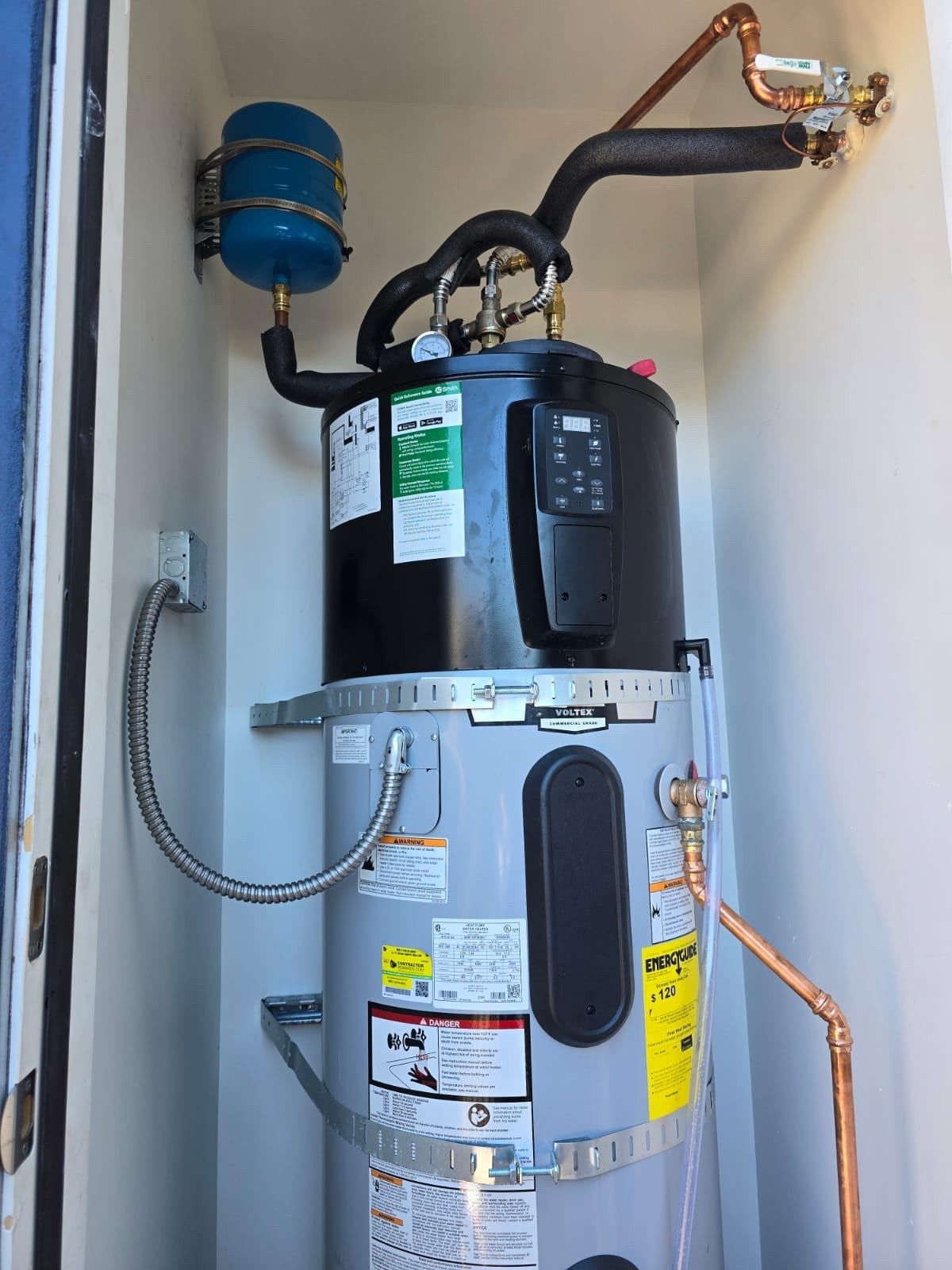 A man is fixing a boiler with a wrench and a towel.