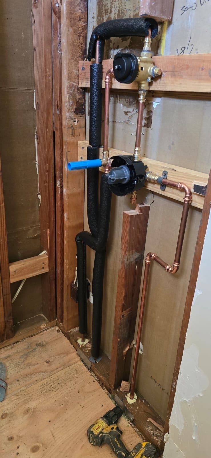 A man is working on a pipe system with a gauge.