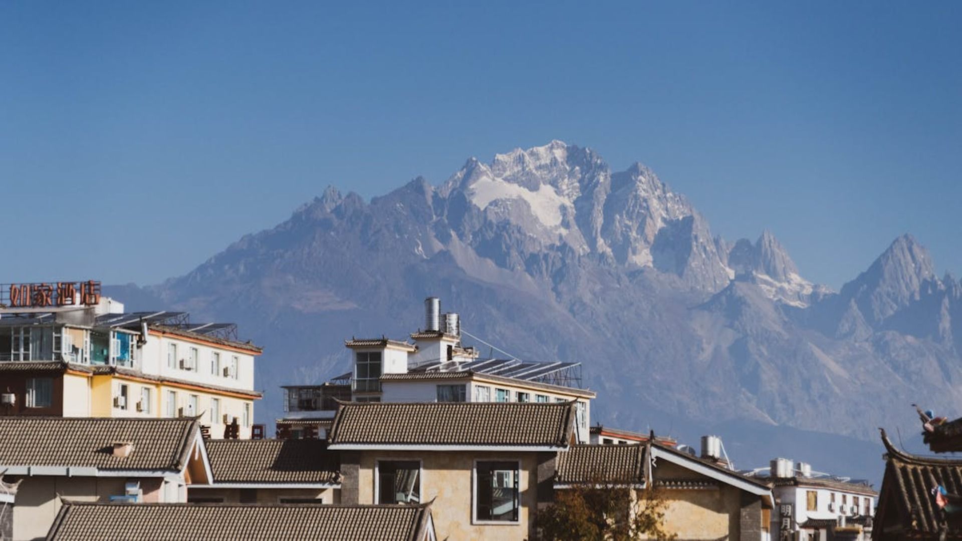 Tejados de un pueblo bajo una montaña nevada bajo un cielo azul despejado