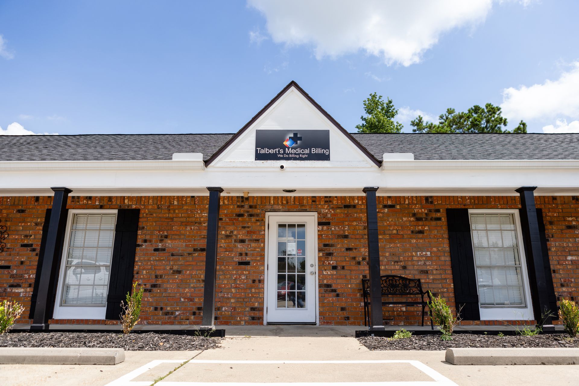 A brick building with a white door and black shutters