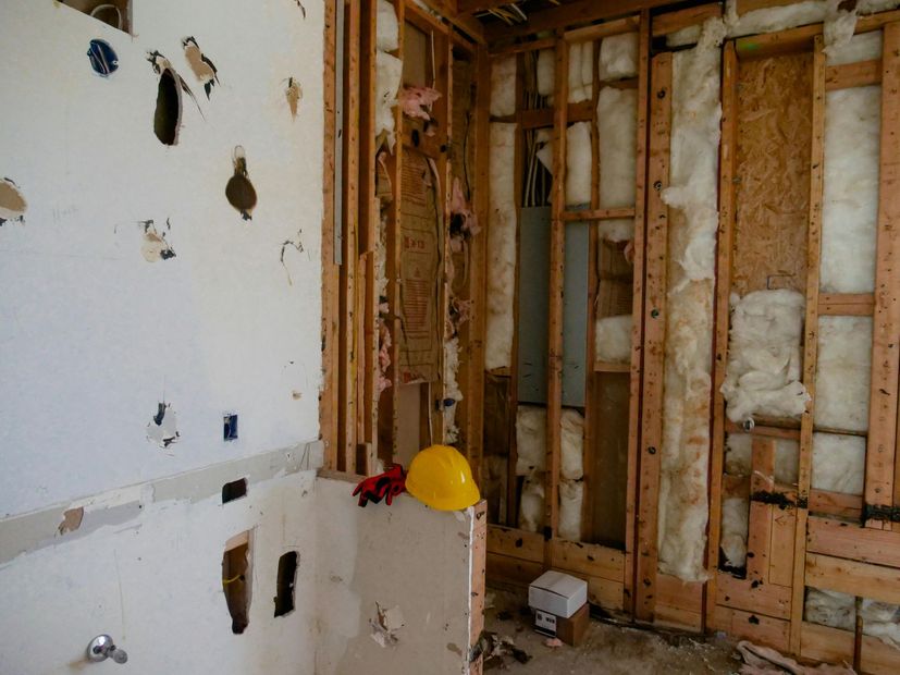 A yellow hard hat is sitting in a bathroom under construction.