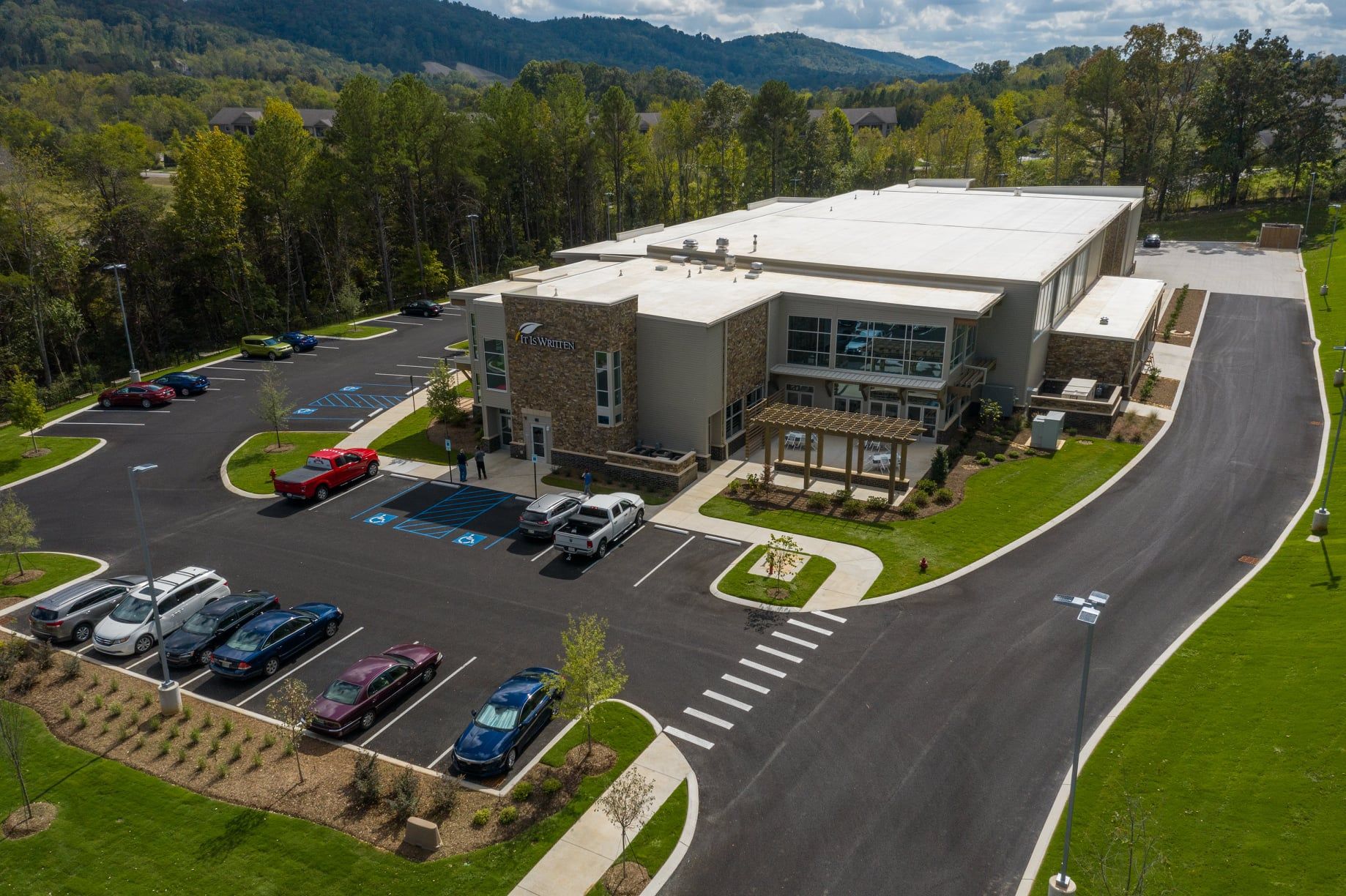 An aerial view of a large building with a lot of cars parked in front of it.