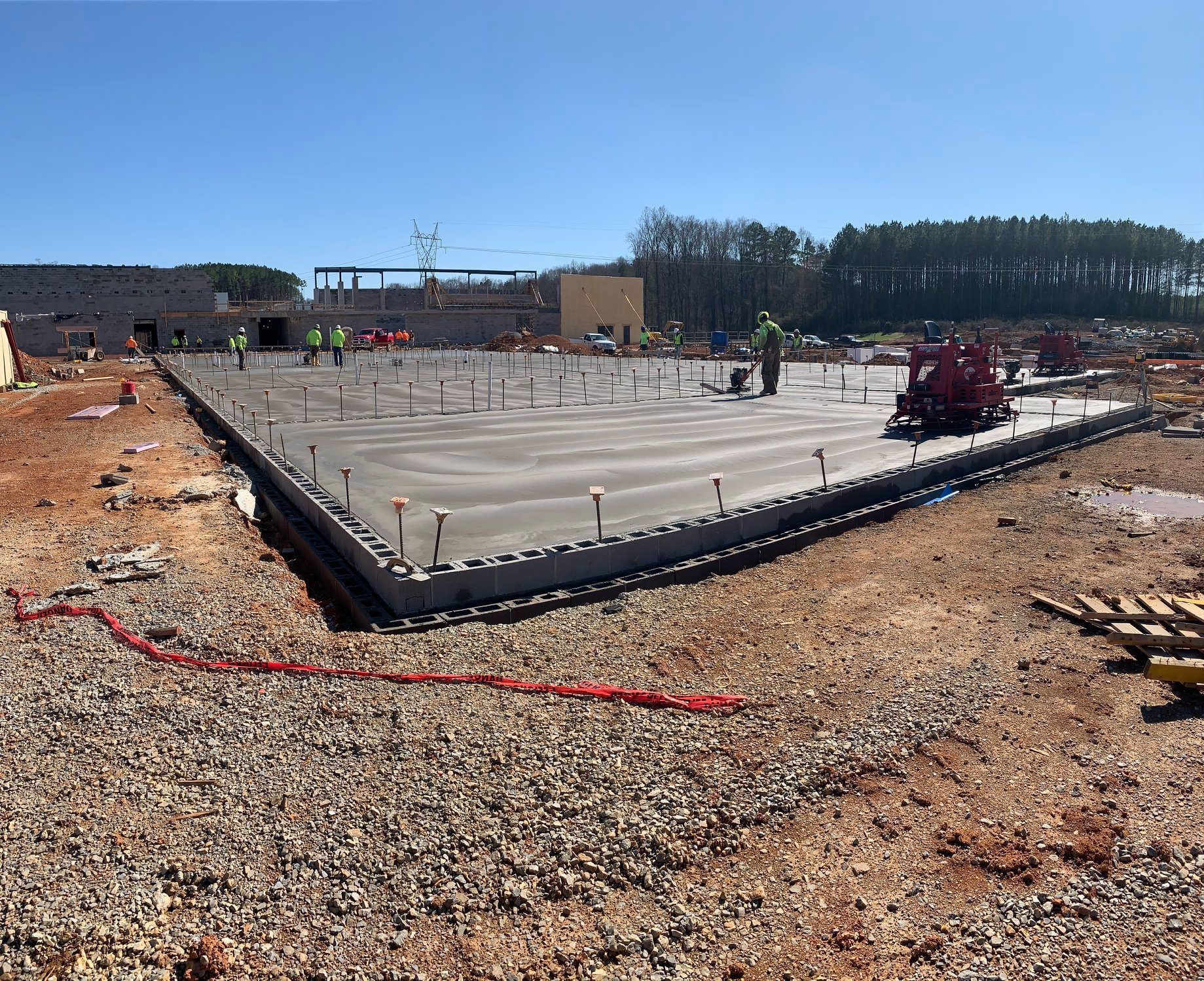 A large concrete slab is being built in a dirt field.