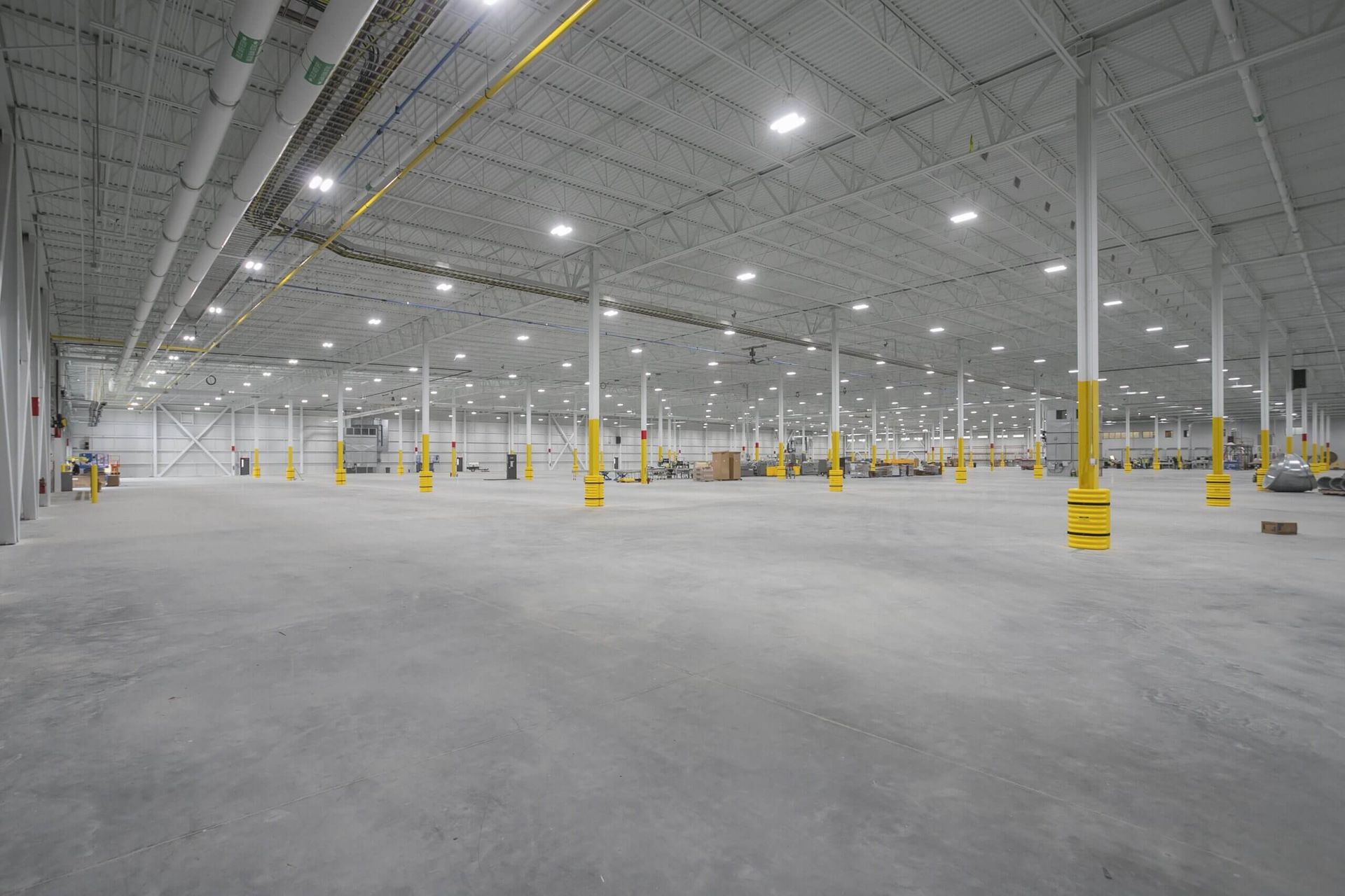 A large empty warehouse with concrete floors and columns.