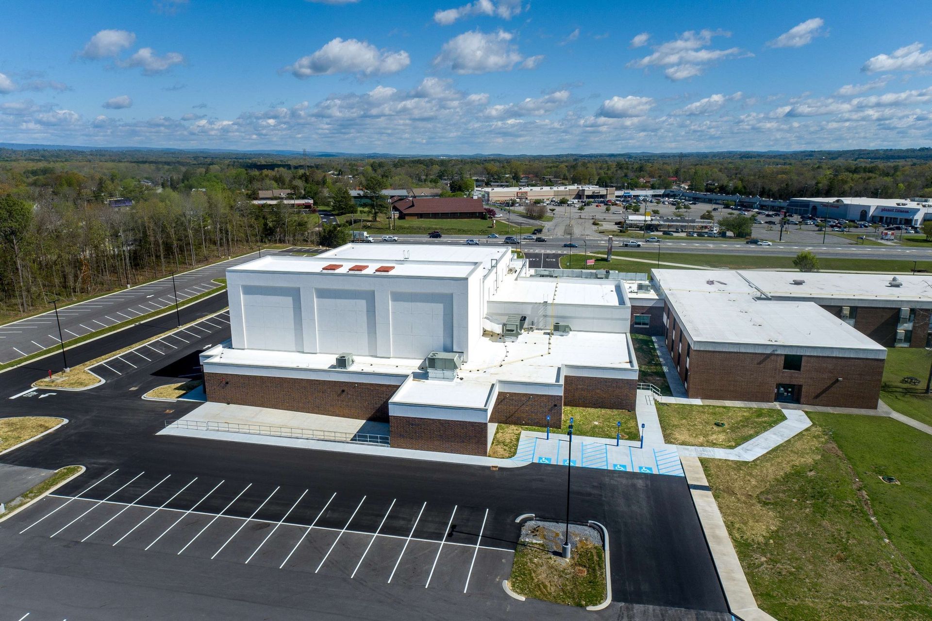 An aerial view of a large building with a parking lot in front of it.
