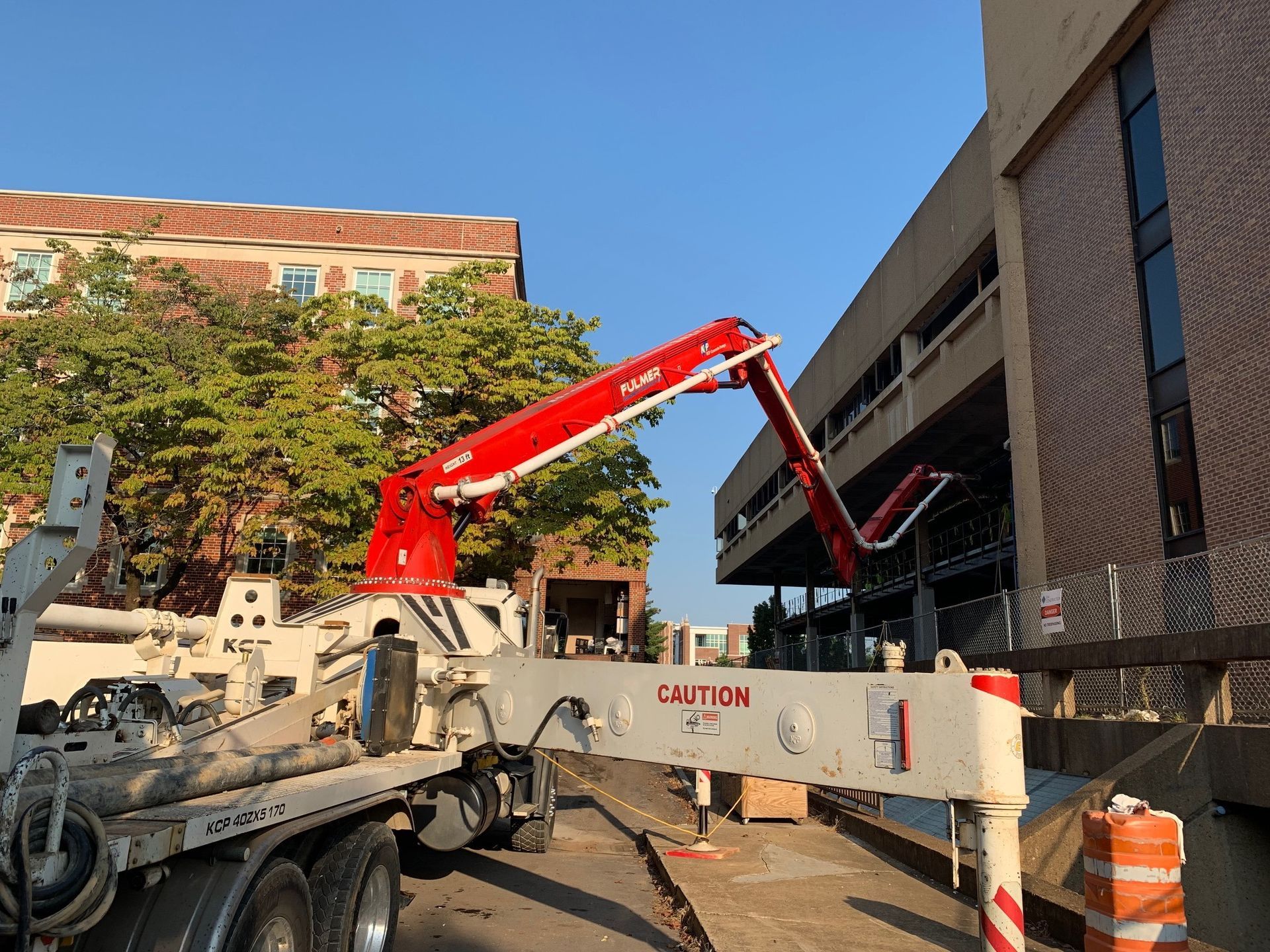 A concrete pump is being used to pump concrete into a parking garage.