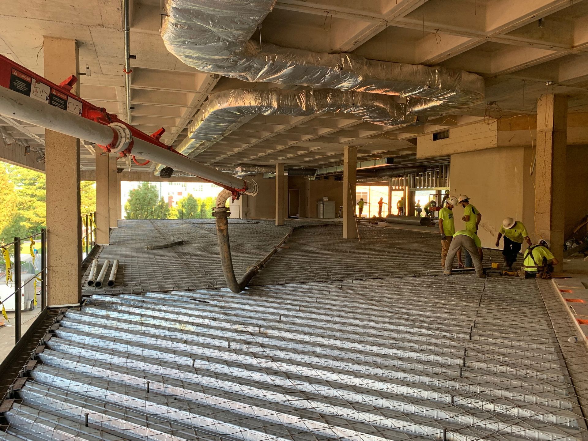 A group of construction workers are working on the floor of a building.