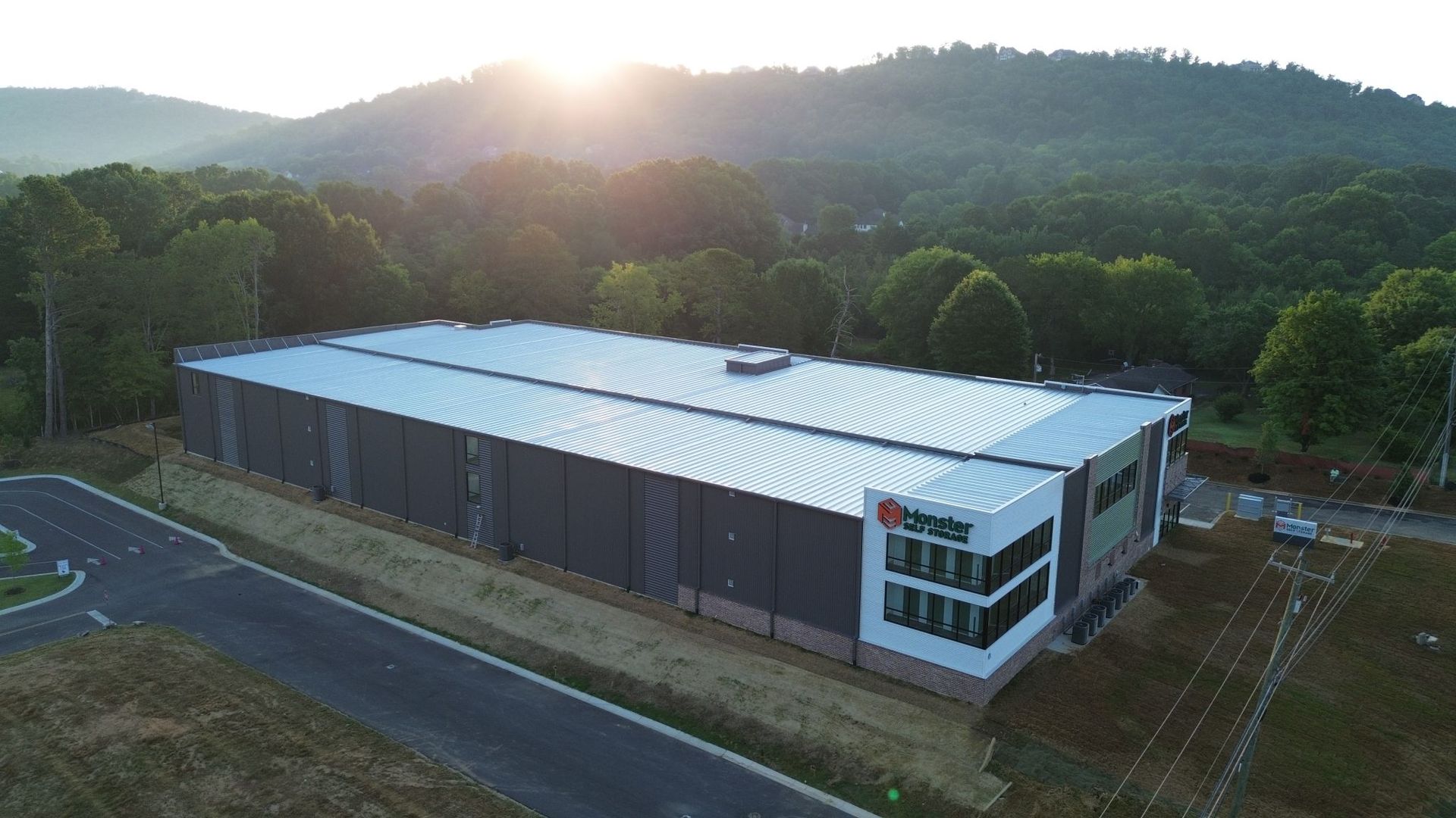 An aerial view of a large building surrounded by trees and mountains.