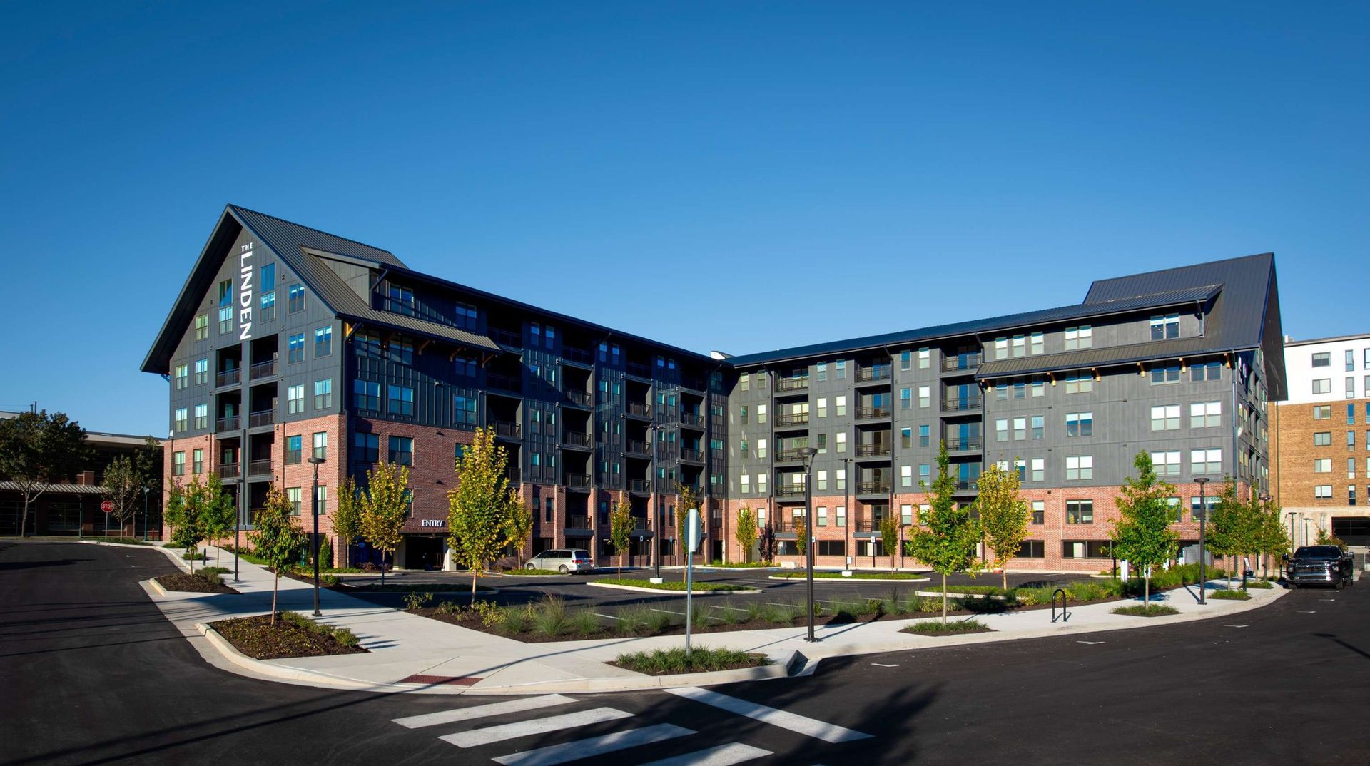 A large apartment building with a lot of windows and trees in front of it.