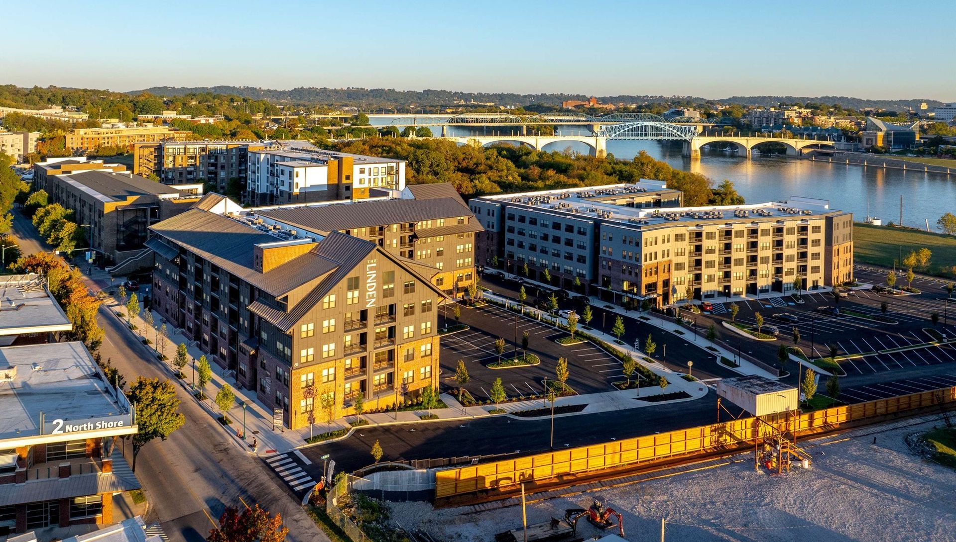 An aerial view of a city with buildings and a river in the background.