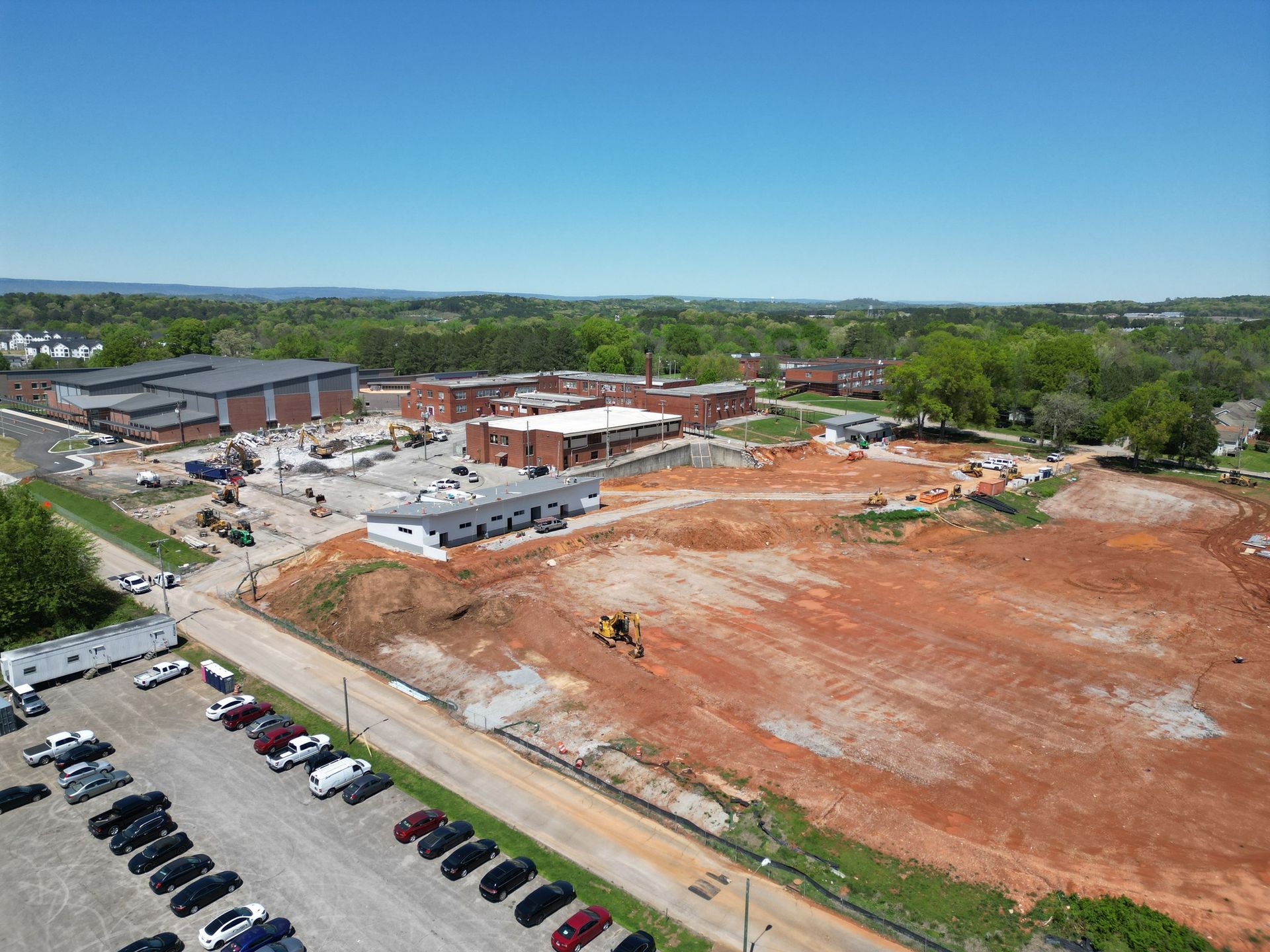 An aerial view of a construction site with a lot of cars parked in front of it.