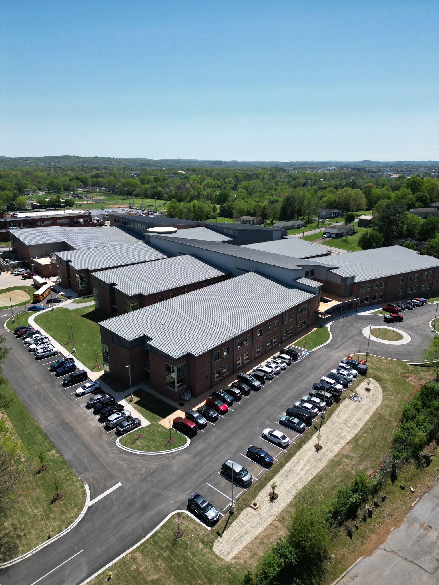 An aerial view of a large building with a lot of cars parked in front of it.