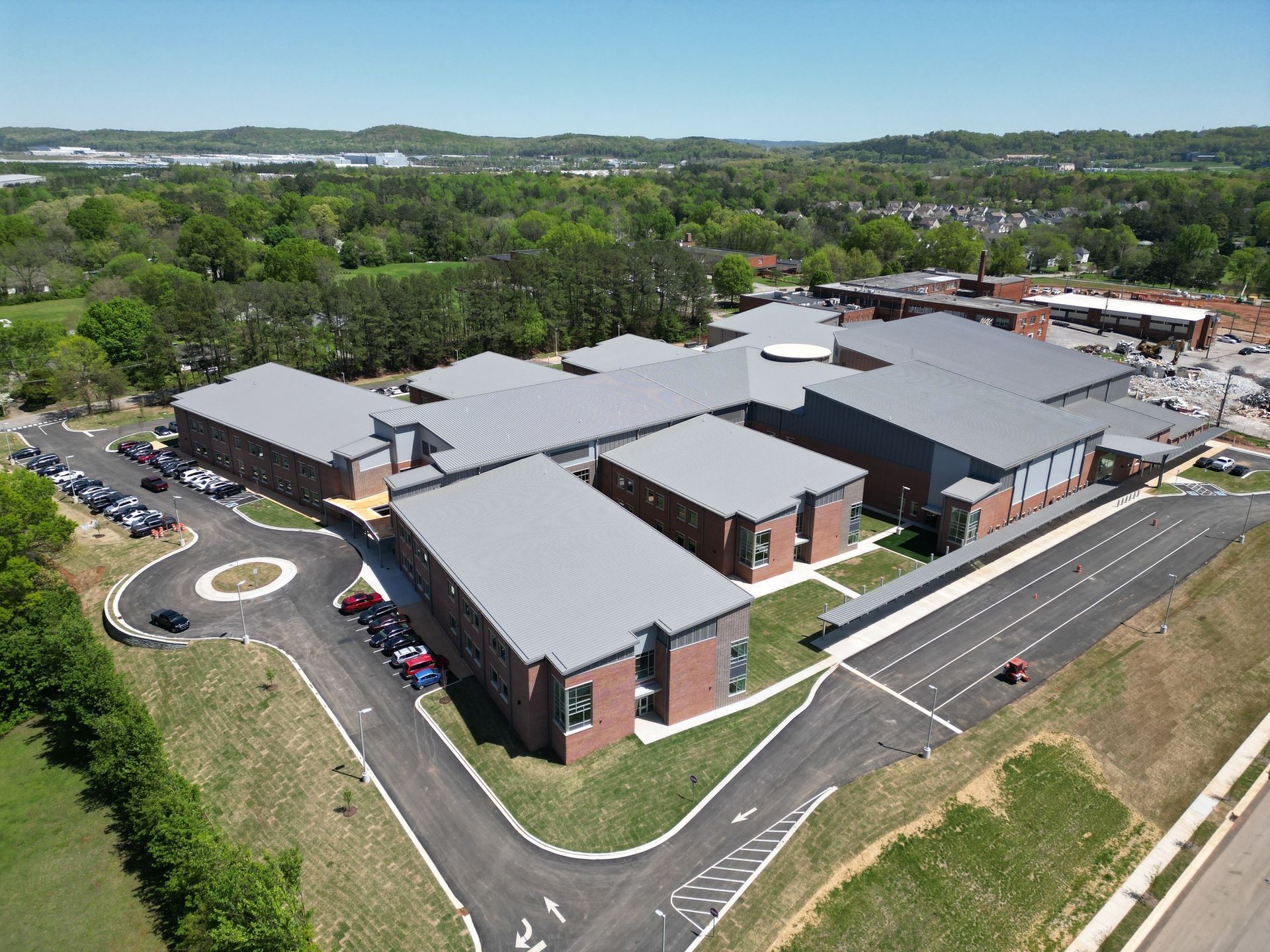 An aerial view of a large building with a lot of cars parked in front of it.