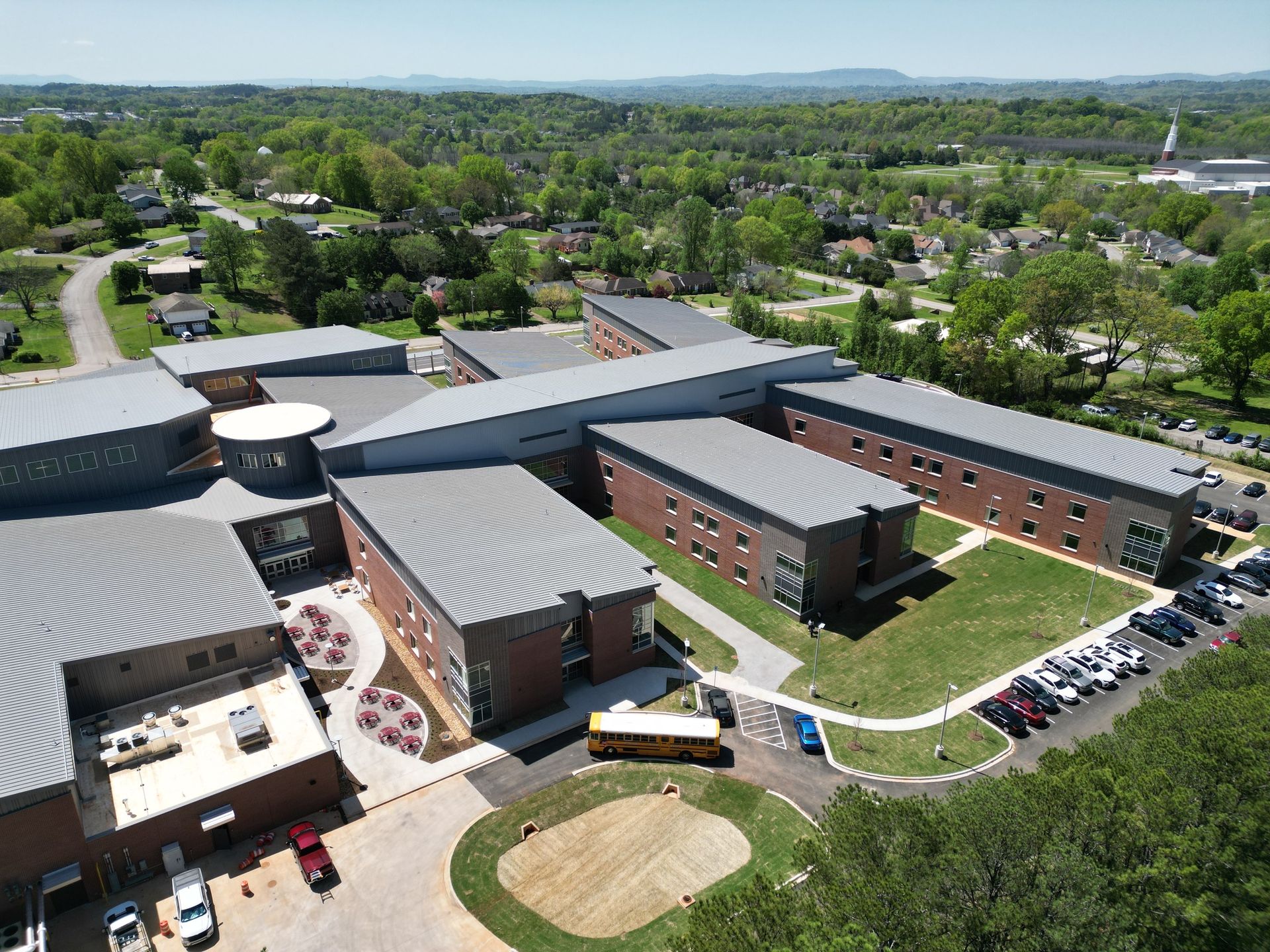 An aerial view of a school with a bus parked in front of it.