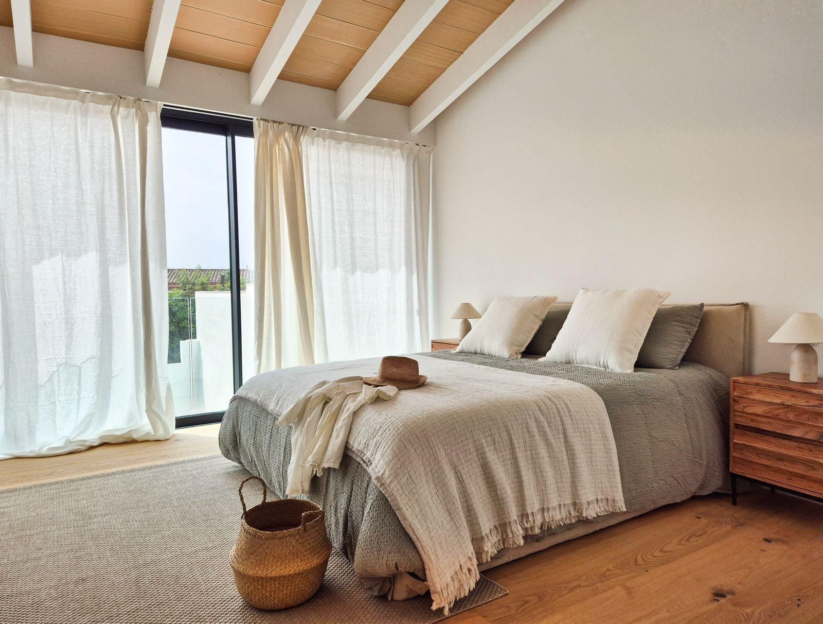 Un dormitorio con una cama grande y una puerta corrediza de vidrio.