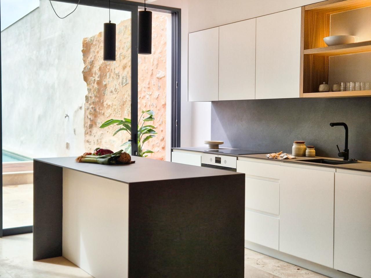 Una cocina con gabinetes blancos y una gran isla en el medio.