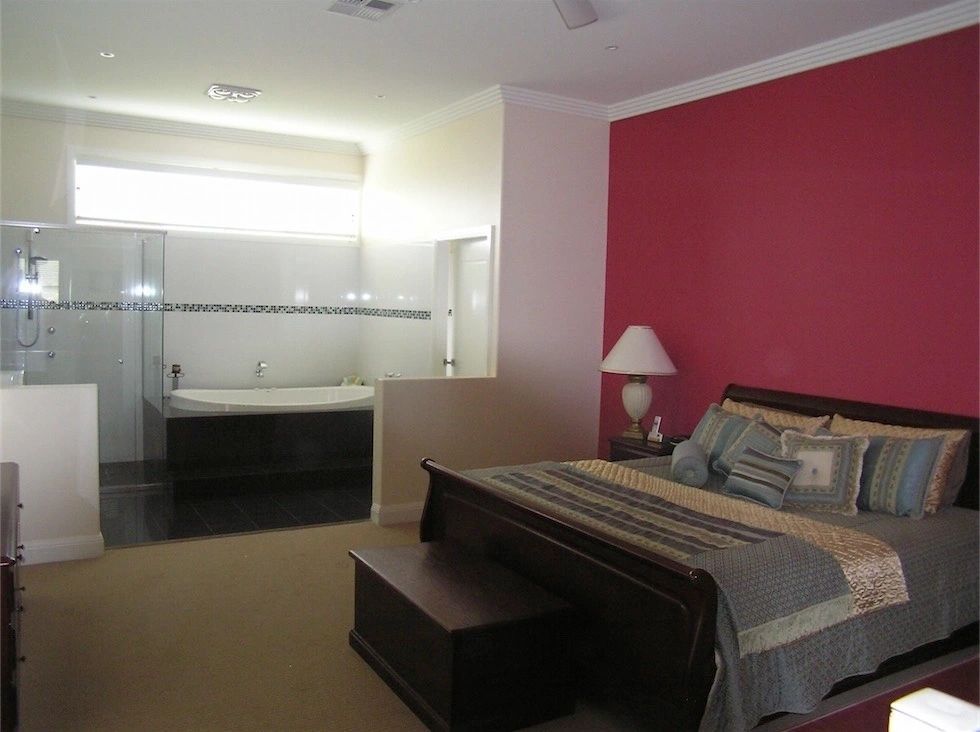 A bedroom with a large bed and a jacuzzi tub