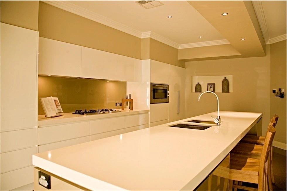 A kitchen with white cabinets and a white counter top