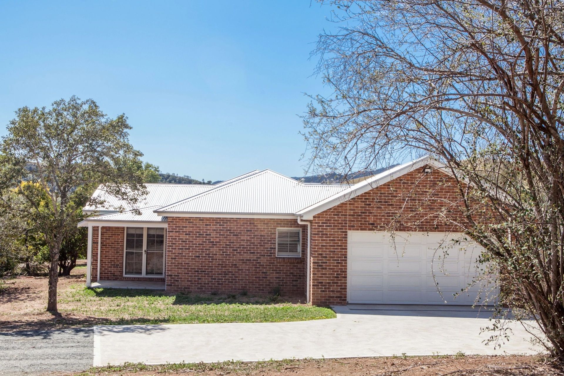 A brick house with a white garage door and a white roof